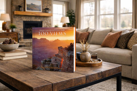 A coffee table book in a modern living room with a beige couch,
