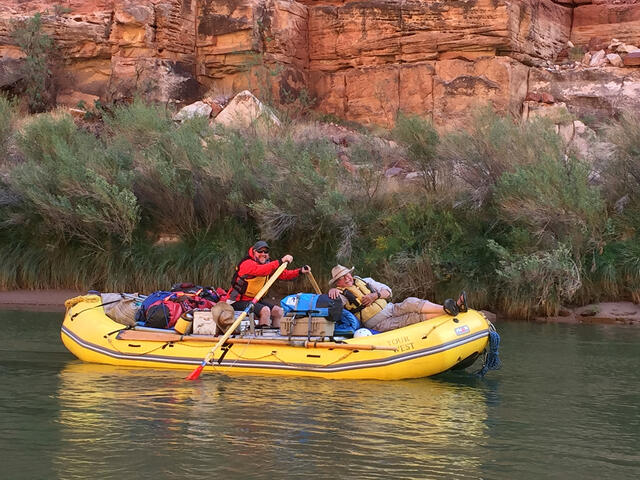 Adam Schallau and David Edwards in a yellow raft on the Colorado River in the Grand Canyon.