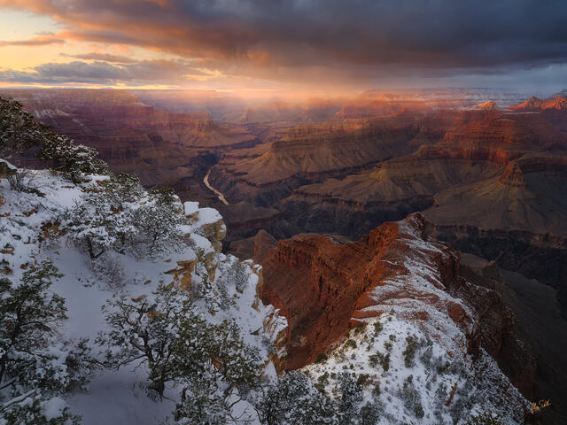 Light passes through snow falling into the Grand Canyon at sunset. From Mohave Point on the South Rim.