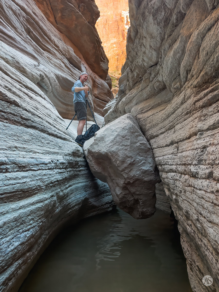 A photographer in the Grand Canyon setting up his camera and tripod to photograph a slot canyon.